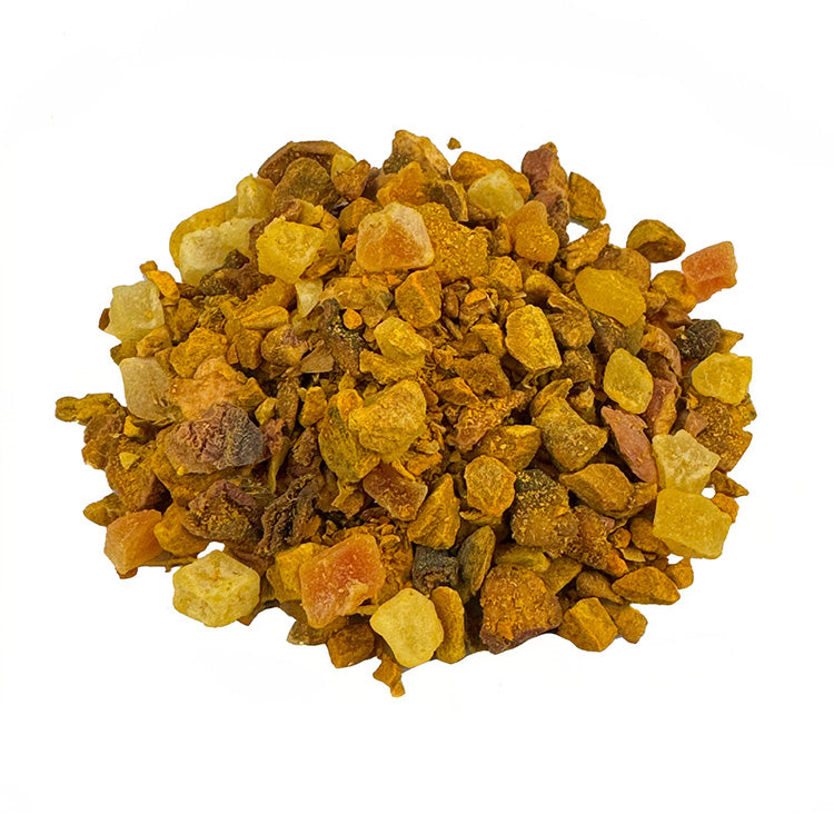 Ein kleiner Haufen Früchtetee Kurkuma Mango Apple. Der Früchtetee hat eine intensive orange Farbe. Die einzelnen Zutaten sind gut zu erkennen. Er sieht sehr lecker aus.
