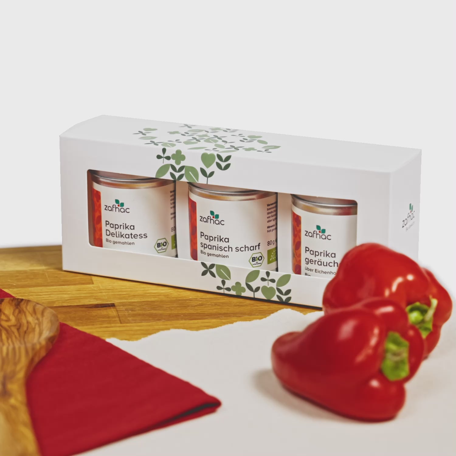 zafhac Paprika Bio-Gewürz-Geschenkset mit Paprika Delikatess, Paprika spanisch scharf und geräuchertem Paprika, dekoriert mit frischen roten Paprikaschoten